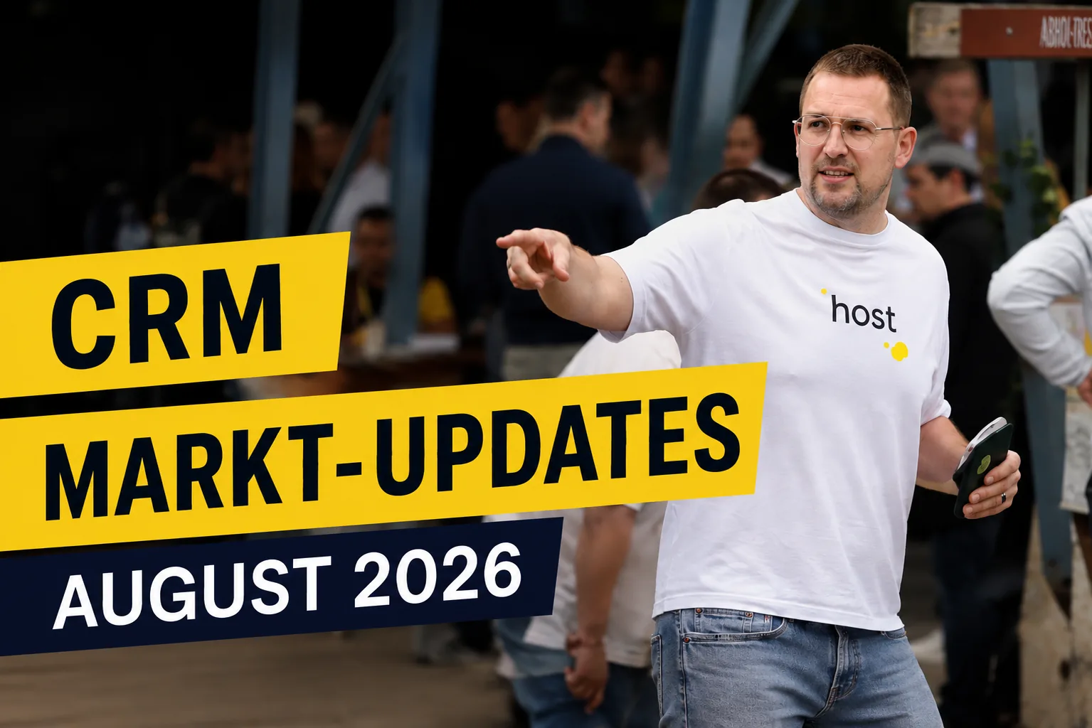 Titelbild „CRM Markt-Updates August 2026“: Mann im weißen host-T-Shirt zeigt auf einer Veranstaltung mit ausgestrecktem Arm zur Seite.